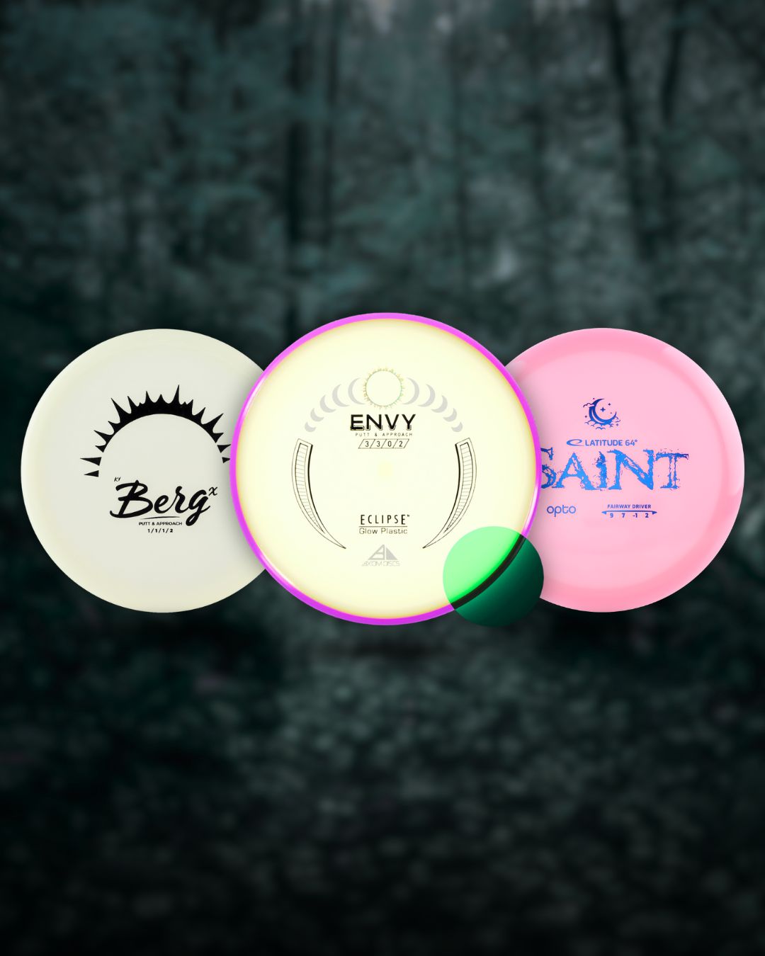 Kolme frisbeegolf glow-kiekkoa hohtamassa pimeässä: Axiom Discs Eclipse Envy, Axiom Discs Eclipse Hex ja Axiom Discs Eclipse Proxy
